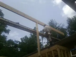 Carpenter setting a ridge beam over a new addition frame — Ice Dam Removal by Roofing Brothers in Panama City Beach