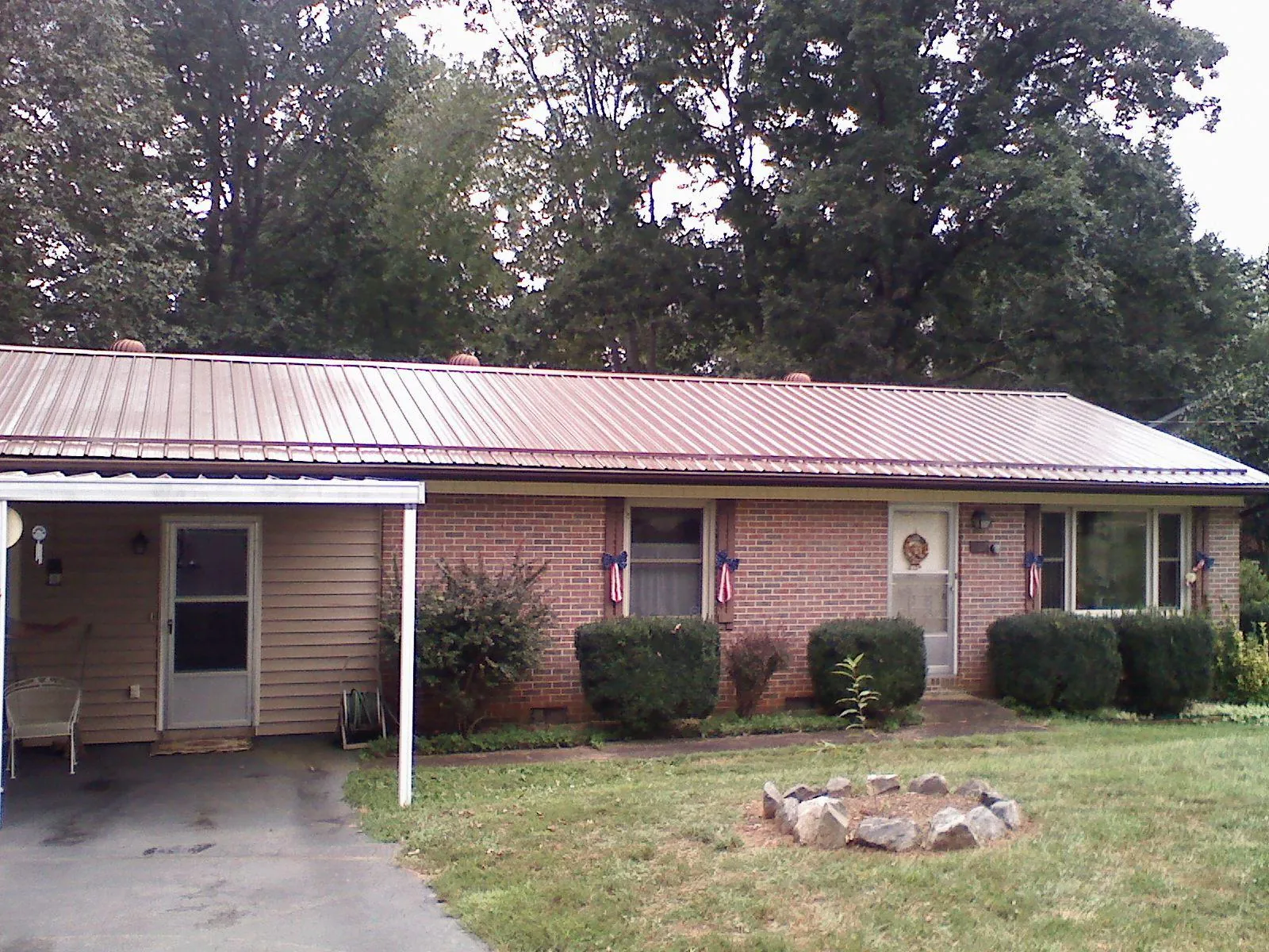 Bronze metal roof and carport on a brick ranch home — Roof Repair work by our crew in Panama City Beach