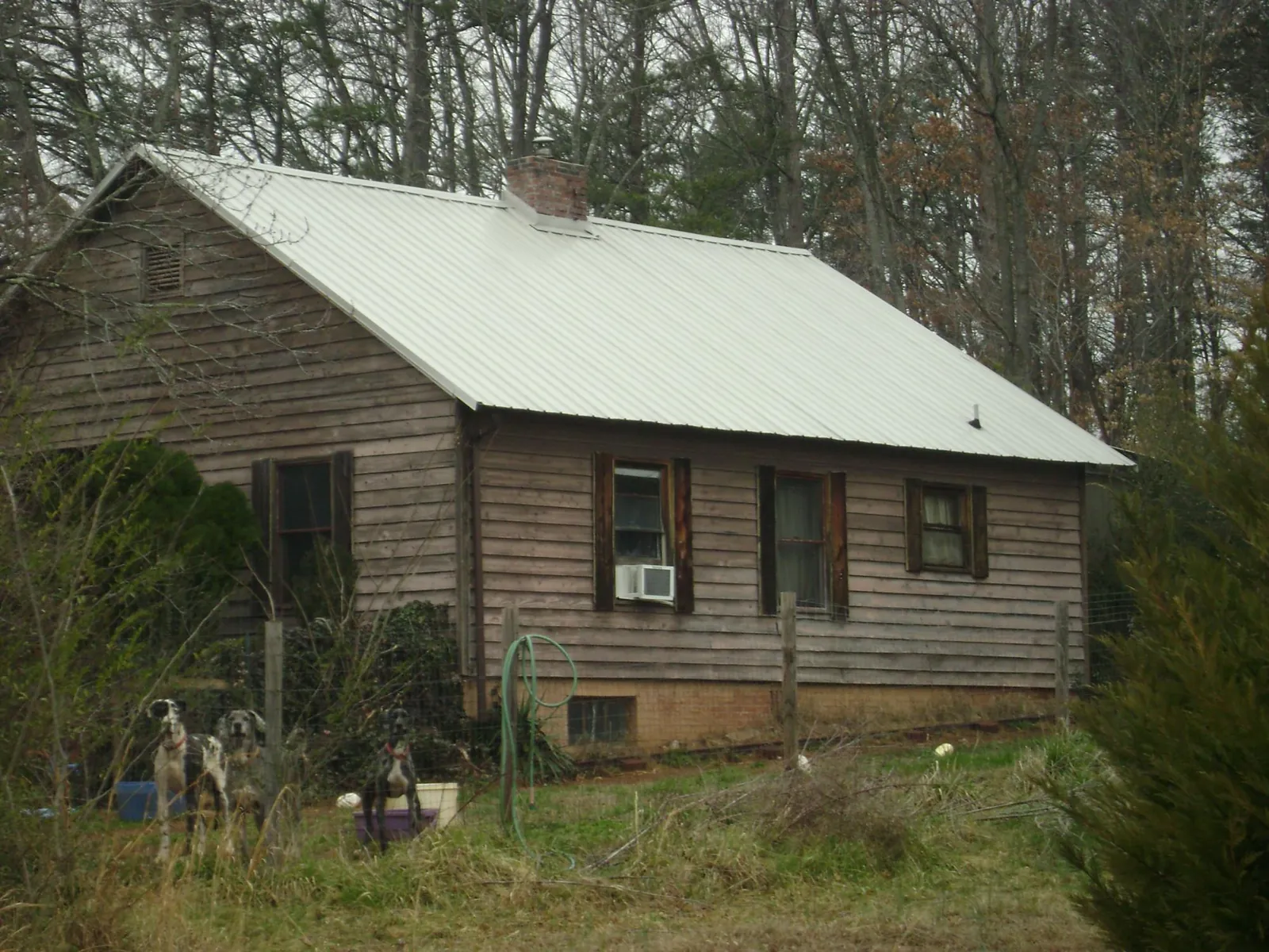 White metal roof on an old wood sided farmhouse, from a Metal Roof Installation job in Panama City Beach